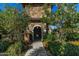 Inviting walkway through a stone archway surrounded by mature trees and landscaping at 18938 W Luke Ave, Litchfield Park, AZ 85340