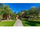 Charming stone entrance to the property featuring lush greenery and a secure gate at 18938 W Luke Ave, Litchfield Park, AZ 85340