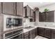 Modern kitchen features stainless steel appliances, mosaic backsplash, and wooden cabinets at 18938 W Luke Ave, Litchfield Park, AZ 85340