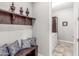 Mud room with a wooden bench, decorative pillows, coat rack, and tile flooring leading to laundry at 18938 W Luke Ave, Litchfield Park, AZ 85340