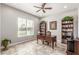 Well-lit home office with classic wood desk, built-in bookshelves, and large window at 18938 W Luke Ave, Litchfield Park, AZ 85340