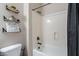 Well-lit bathroom featuring decorative shelving and a shower-tub combination at 21397 S 215Th Way, Queen Creek, AZ 85142