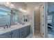 Bathroom featuring dual sinks, sleek gray cabinets, and a bright window, offering a serene space at 21397 S 215Th Way, Queen Creek, AZ 85142