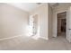 Well-lit bedroom featuring neutral carpeting, a closet with white doors, and an open doorway at 21397 S 215Th Way, Queen Creek, AZ 85142