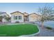 Inviting single-story home with well-maintained synthetic grass, desert landscaping, and a spacious three-car garage at 21397 S 215Th Way, Queen Creek, AZ 85142