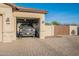 Spacious two-car garage with ample storage space and an open door, with brick paved driveway at 21397 S 215Th Way, Queen Creek, AZ 85142