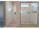 A well-lit shower with a glass surround, features a rainfall shower head and built-in shampoo shelves at 21397 S 215Th Way, Queen Creek, AZ 85142