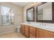 Bathroom featuring double sinks with wooden cabinets, and a large window at 2142 E Wildhorse Dr, Chandler, AZ 85286