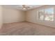 Neutral bedroom with a ceiling fan, plush carpet, and a window providing natural light at 2142 E Wildhorse Dr, Chandler, AZ 85286