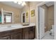 A bright bathroom with a modern vanity, a spacious mirror, and an adjacent toilet room at 21609 N Diamond Dr, Maricopa, AZ 85138