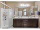 Well-lit bathroom features double sinks, a glass shower, and modern fixtures at 21609 N Diamond Dr, Maricopa, AZ 85138