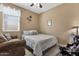 Cozy bedroom featuring a comfortable bed, soft lighting, and a decorative side chair at 21609 N Diamond Dr, Maricopa, AZ 85138