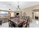 Open dining area featuring a wooden table, marble floors, and a charming chandelier at 21609 N Diamond Dr, Maricopa, AZ 85138