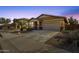 Beautiful single-Gathering home featuring a two-car garage, desert landscaping, and warm exterior lighting at 21609 N Diamond Dr, Maricopa, AZ 85138