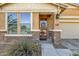 Close-up of the home's front entrance, highlighting the decorative door, stone accents, and manicured bushes at 21609 N Diamond Dr, Maricopa, AZ 85138