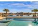 Beautiful waterfront pool and spa reflecting the sky, lined with palm trees offering a serene and luxurious outdoor experience at 21609 N Diamond Dr, Maricopa, AZ 85138