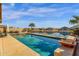 Stunning pool and spa overlooking the waterfront, complimented by palm trees and blue skies for a luxurious experience at 21609 N Diamond Dr, Maricopa, AZ 85138