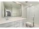 Bright bathroom with a white vanity, large mirror, and a glass-enclosed shower at 2204 W Minton St, Phoenix, AZ 85041