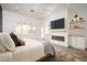 Bright main bedroom featuring a fireplace, TV, and white wooden decor, creating a relaxing and inviting space at 23420 S 202Nd St, Queen Creek, AZ 85142