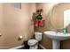 Well-lit powder room featuring a pedestal sink, toilet, and decorative accents, perfect for guests at 2635 E Chester Dr, Chandler, AZ 85286