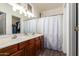 Bathroom features a dual sink vanity, a large mirror, modern lighting, and a shower with curtain at 2635 E Chester Dr, Chandler, AZ 85286