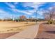 Expansive park landscape with a meandering concrete pathway leading to play areas under a bright, blue sky at 2635 E Chester Dr, Chandler, AZ 85286