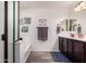 Bright bathroom featuring wood look flooring, double sink vanity, and a shower-tub combination at 2748 E Cherry Hill Dr, Gilbert, AZ 85298