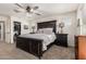 Well-lit bedroom with carpet, ceiling fan, dark wood furniture, and a closet at 2748 E Cherry Hill Dr, Gilbert, AZ 85298