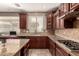 Close up of a kitchen with beautiful granite countertops and dark wood cabinetry; modern stainless steel appliances at 2811 W Glenhaven Dr, Phoenix, AZ 85045