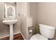 A stylish powder room featuring a pedestal sink, modern fixtures, and wood flooring at 2811 W Glenhaven Dr, Phoenix, AZ 85045