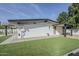 Backyard of home featuring artificial grass, gravel landscaping, and a covered patio at 2925 E North Ln, Phoenix, AZ 85028