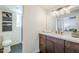 Bathroom vanity with a white marble countertop, wooden cabinets and decorative lighting fixture at 2925 E North Ln, Phoenix, AZ 85028