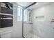 Modern bathroom with glass enclosed shower and marble tile surround, with black trim and fixtures at 2925 E North Ln, Phoenix, AZ 85028