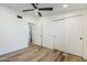 Bright bedroom featuring a ceiling fan, wood-look floors, and double sliding-door closet at 2925 E North Ln, Phoenix, AZ 85028