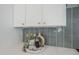 Bright kitchen details, showing decor and stylish backsplash, with white cabinets and countertops at 2925 E North Ln, Phoenix, AZ 85028