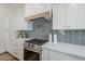 Close-up of a gourmet kitchen with stainless steel gas range, wood hood, and white quartz countertop at 2925 E North Ln, Phoenix, AZ 85028