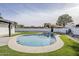 Backyard featuring an in-ground pool bordered with artificial grass and concrete at 2925 E North Ln, Phoenix, AZ 85028