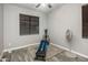 Neutral bedroom with a ceiling fan, window with blinds, and home gym equipment at 3518 S Posse Trl, Gilbert, AZ 85297