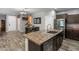 Modern kitchen featuring an island sink and stainless steel refrigerator in a brightly lit open space at 3518 S Posse Trl, Gilbert, AZ 85297