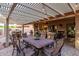 Beautiful covered patio with outdoor kitchen, ample seating, and stylish lighting at 3544 N 149Th Ave, Goodyear, AZ 85395