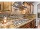 Elegant kitchen with granite counters, tile backsplash, and stainless steel gas cooktop at 3544 N 149Th Ave, Goodyear, AZ 85395