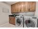 Functional laundry room featuring modern washer and dryer, and ample cabinet space at 3544 N 149Th Ave, Goodyear, AZ 85395