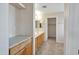 Bathroom vanity with wood cabinets, tile floors, and access to a walk-in closet at 3614 W Alyssa Ln, Phoenix, AZ 85083