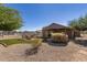 Expansive backyard featuring artificial turf, gravel landscaping, a fire pit and covered patio at 3720 E Vista Grande --, San Tan Valley, AZ 85140