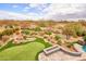 Aerial view of a lush putting green, desert landscaping, rock water feature, and fire pit at 4365 E Milton Dr, Cave Creek, AZ 85331