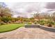 Beautiful backyard showcasing a putting green, a rock waterfall, and a cozy fire pit for year-round outdoor enjoyment at 4365 E Milton Dr, Cave Creek, AZ 85331