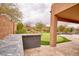 Outdoor kitchen and putting green in landscaped backyard with rock features and mature trees at 4365 E Milton Dr, Cave Creek, AZ 85331