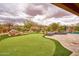 Relaxing backyard featuring a putting green, a rock waterfall, and a fire pit, ideal for outdoor entertaining at 4365 E Milton Dr, Cave Creek, AZ 85331