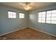 A bright bedroom has three windows for natural light with neutral walls, carpet, and electrical outlets at 4365 E Milton Dr, Cave Creek, AZ 85331