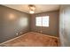 A simple bedroom featuring neutral walls and carpet, with a ceiling fan, and a window providing natural light at 4365 E Milton Dr, Cave Creek, AZ 85331